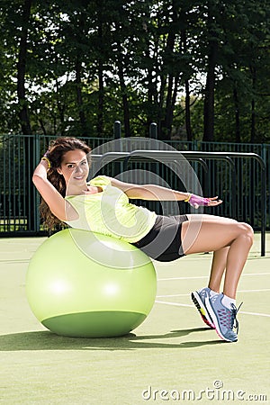 Training on the fit ball. Young woman doing sports exercises on the ball for training Stock Photo