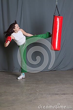 Training woman kicks punching bag Stock Photo