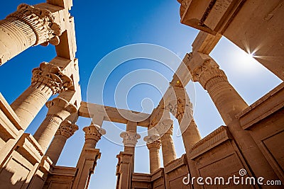 Trajan Kiosk at Philae inside view. Columns decorated with hyeroglyphs. Lens flare effect from the sun Stock Photo