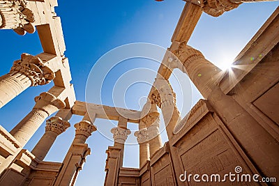 Trajan Kiosk at Philae inside view. Columns decorated with hyeroglyphs. Lens flare effect from the sun Stock Photo