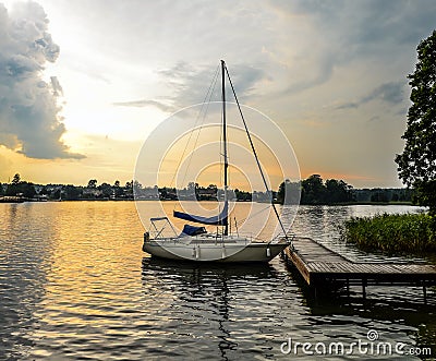 Beautiful summer landscape of Trakai lake and little sport yacht. Lake and sunset sky. Editorial Stock Photo