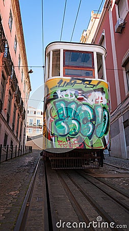 Tram with graffiti in narrow steep street in Lisbon Editorial Stock Photo