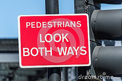 Pedestrians look both ways red board Stock Photo