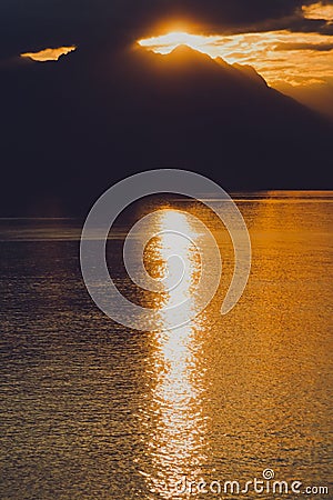 Tranquil lake illuminated by the setting sun, casting a mesmerizing reflection Stock Photo