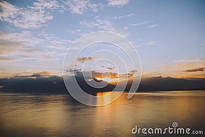 Tranquil lake illuminated by the setting sun, casting a mesmerizing reflection Stock Photo