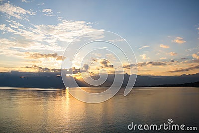 Tranquil lake illuminated by the setting sun, casting a mesmerizing reflection Stock Photo