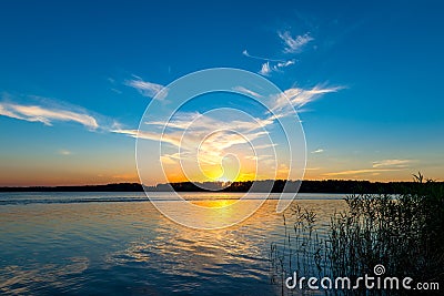 Tranquil lake and the setting sun Stock Photo