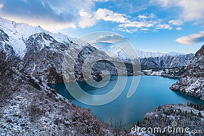 Tranquil landscape of an alpine lake, surrounded by majestic snow-covered mountains Stock Photo