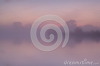 Tranquil misty sunrise over lake Stock Photo