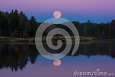 Tranquil night scene with full moon reflecting on calm lake Stock Photo