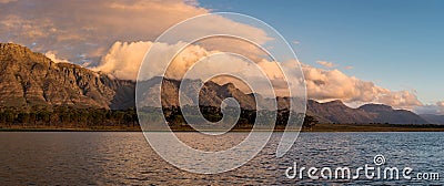 A tranquil panoramic landscape of a beautiful mountain range covered with yellow clouds Stock Photo