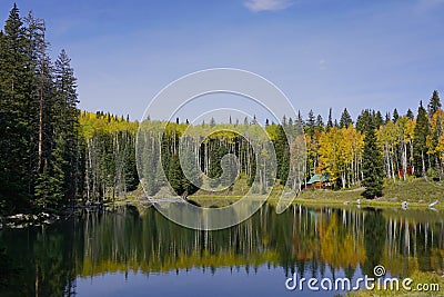 Cabin by a pond surrounded by fall color Stock Photo