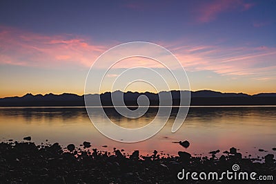 Tranquil Sunrise over Calm Lake Stock Photo