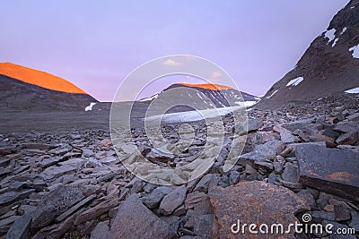 Tranquil vibrant sunset with insane red coloration of the glacier valley mountains Stock Photo