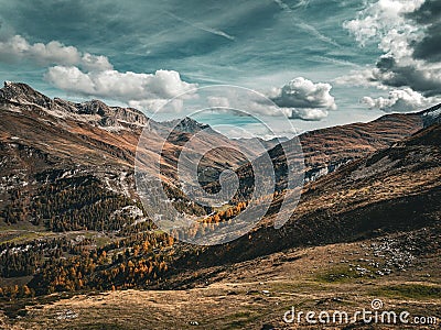 Tranquil view of the Swiss Alps in Avers, with autumn trees and grass in the valley Stock Photo