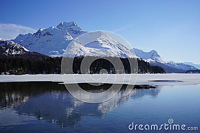 Tranquil winter landscape featuring a serene lake with a dusting of snow Stock Photo