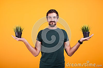 Tranquility concept image of relaxed man holding two pots of grass Stock Photo