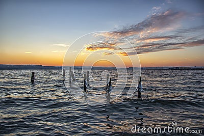 Lake with old timber jetty pillars with ice protruding from the water Stock Photo