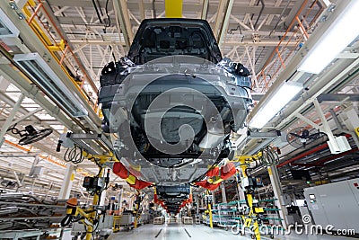 Transfer of car body bottom view. Robotic equipment makes the Assembly of car. Modern car Assembly at factory Stock Photo