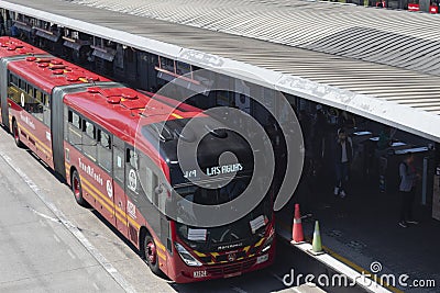 A transmilenio bus piciking up passenger at Portal del norte central station on sunny day Editorial Stock Photo