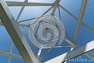 Transmission tower, view from below. Overhead pylon power line tower, distribution and transmit electrical energy across large Stock Photo