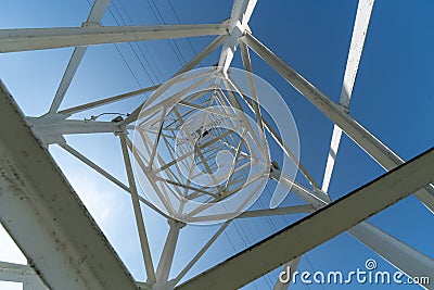 Transmission tower, view from below. Overhead pylon power line tower, distribution and transmit electrical energy across large Stock Photo