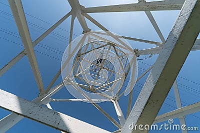 Transmission tower, view from below. Overhead pylon power line tower, distribution and transmit electrical energy across large Stock Photo