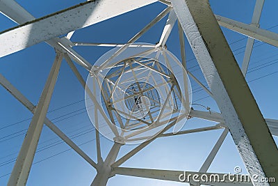 Transmission tower, view from below. Overhead pylon power line tower, distribution and transmit electrical energy across large Stock Photo