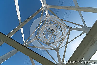 Transmission tower, view from below. Overhead pylon power line tower, distribution and transmit electrical energy across large Stock Photo