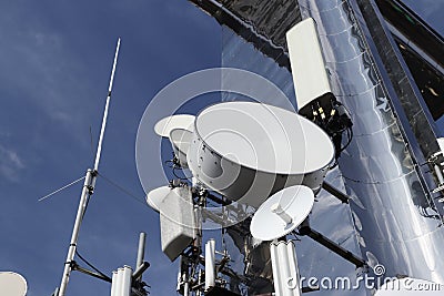 Transmitters of radio signals. electric network. Ecology of power. Technical pole. Iron construction on a blue sky. Strategic Stock Photo