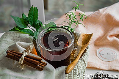 Transparent Cup of tea brewed with adjacent wooden spoons. Cinnamon sticks. Tea time. Tea leafs, Flat Lay Stock Photo