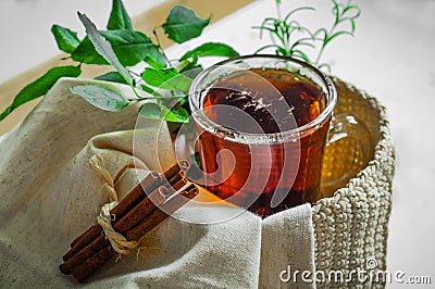 Transparent Cup of tea brewed with adjacent wooden spoons. Cinnamon sticks. Tea time. Tea leafs, Flat Lay Stock Photo