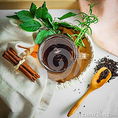 Transparent Cup of tea brewed with adjacent wooden spoons. Cinnamon sticks. Tea time. Tea leafs, Flat Lay Stock Photo