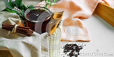 Transparent Cup of tea brewed with adjacent wooden spoons. Cinnamon sticks. Tea time. Tea leafs, Flat Lay Stock Photo