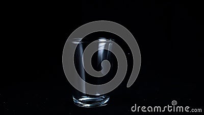 Transparent glass cup on black background. Frame. Glass for tea stands empty glint from faint white light on Stock Photo