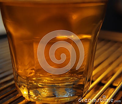 A transparent glass filled with water.The cups are placed on the counter of the coffee machine.The transparent glass is an accesso Stock Photo