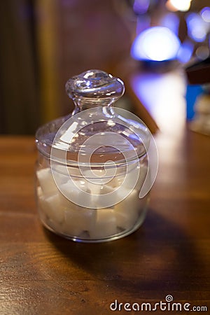 Transparent glass jar with white sugar on the table Stock Photo