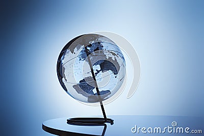 Transparent globe on stand in studio Stock Photo