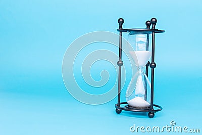 Transparent hourglass, Blue background. On the right. Copy, text space Stock Photo