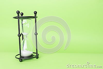 Transparent hourglass, Green background. On the left. Copy, text space Stock Photo