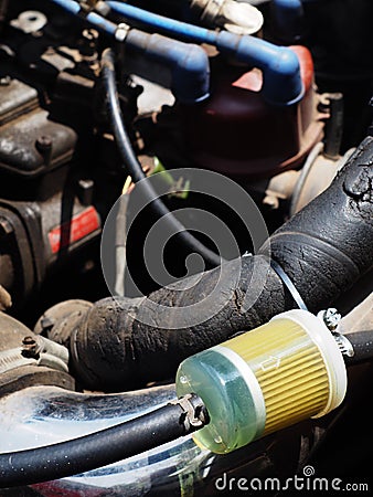 Transparent plastic gasoline fuel filter with light blue fuel in an old school style sport vehicle car Stock Photo