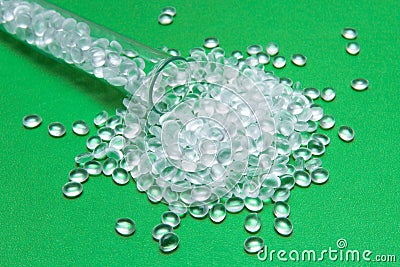 Transparent Polyethylene granules on a green background.The concept of free bpa. HDPE Plastic pellets. Plastic Raw material . ID Stock Photo