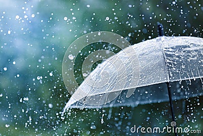 Transparent umbrella under rain against water drops splash background. Rainy weather concept Stock Photo