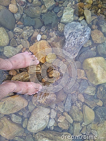 Transparent water surface with human feet from top view Stock Photo