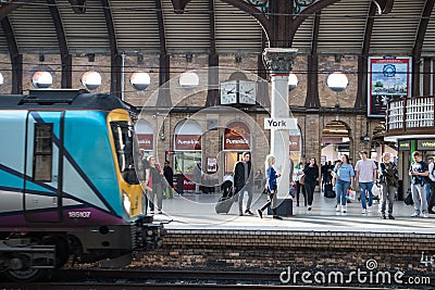 Transpennine Express train on a platform with York place name sign and people waiting on the platform Editorial Stock Photo