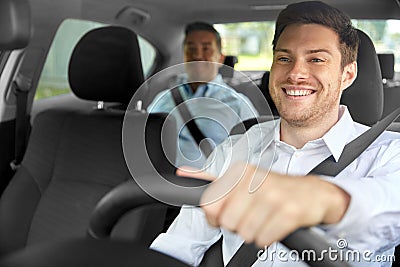 Male taxi driver driving car with passenger Stock Photo