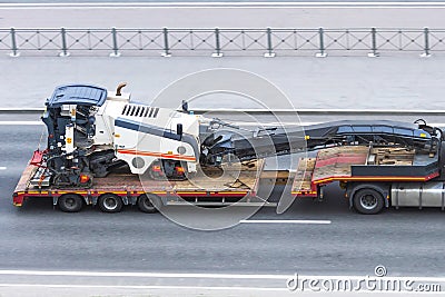 Transportation of equipment for cutting and removing old asphalt pavement for road repair on a truck platform of a truck trailer Stock Photo