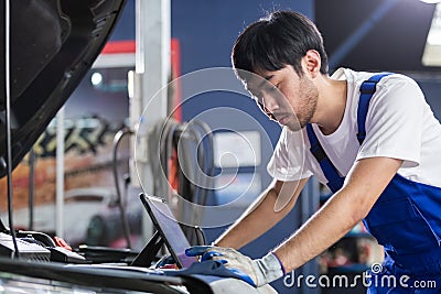 Transportation repair service concept, Repairman auto mechanic using tablet to check for damage inside engine. man worker service Stock Photo