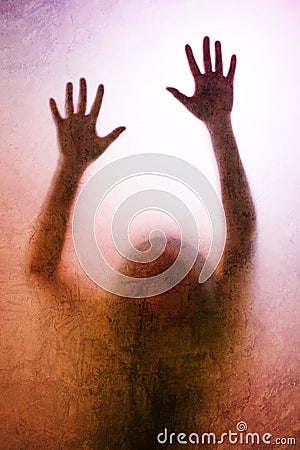 Trapped woman, back lit silhouette of hands behind matte glass Stock Photo