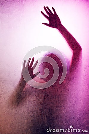 Trapped woman, back lit silhouette of hands behind matte glass Stock Photo